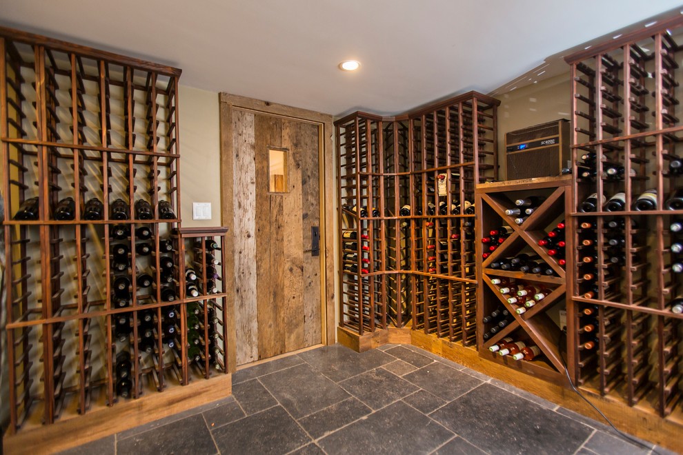 Mid-sized country wine cellar in Boston with marble floors, storage racks and black floor.