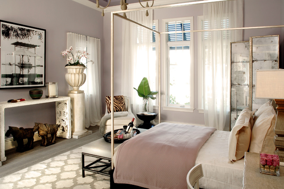 Design ideas for a mid-sized tropical guest bedroom in Miami with purple walls and medium hardwood floors.