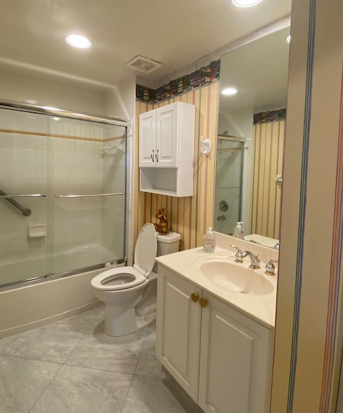 This is an example of a small world-inspired shower room bathroom in Other with a single sink and wallpapered walls.