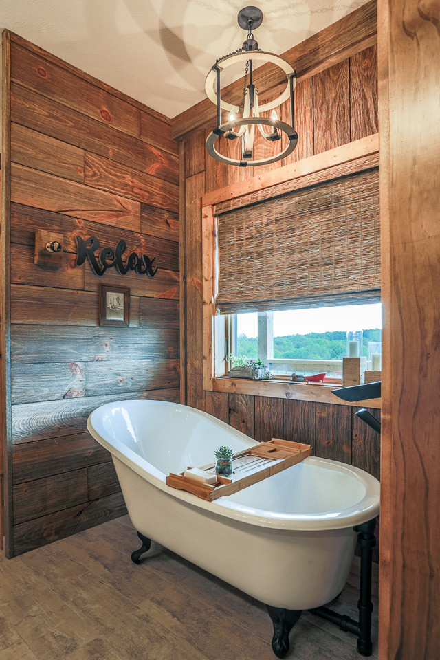 Photo of a mid-sized country master bathroom in Omaha with recessed-panel cabinets, a claw-foot tub, an open shower, travertine, beige walls, porcelain floors, an undermount sink, onyx benchtops, grey floor, an open shower and white benchtops.