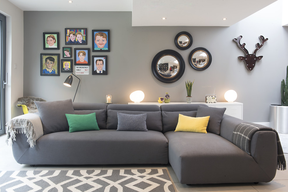 This is an example of a contemporary open concept living room in London with grey walls.