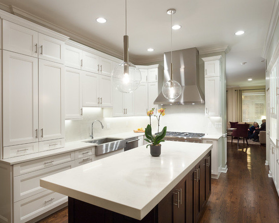 Large transitional l-shaped dark wood floor eat-in kitchen photo in Chicago with a farmhouse sink, shaker cabinets, white cabinets, marble countertops, white backsplash, subway tile backsplash, stainless steel appliances and an island