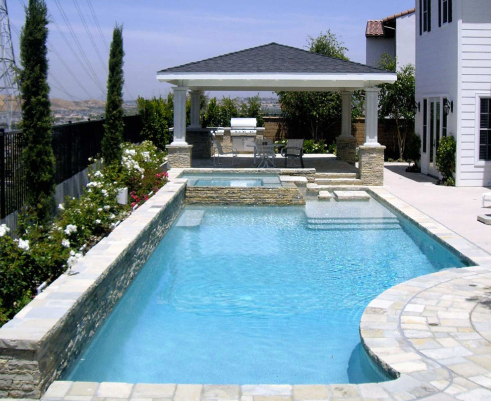 Design ideas for a mid-sized traditional backyard custom-shaped natural pool in Orange County with a hot tub and tile.