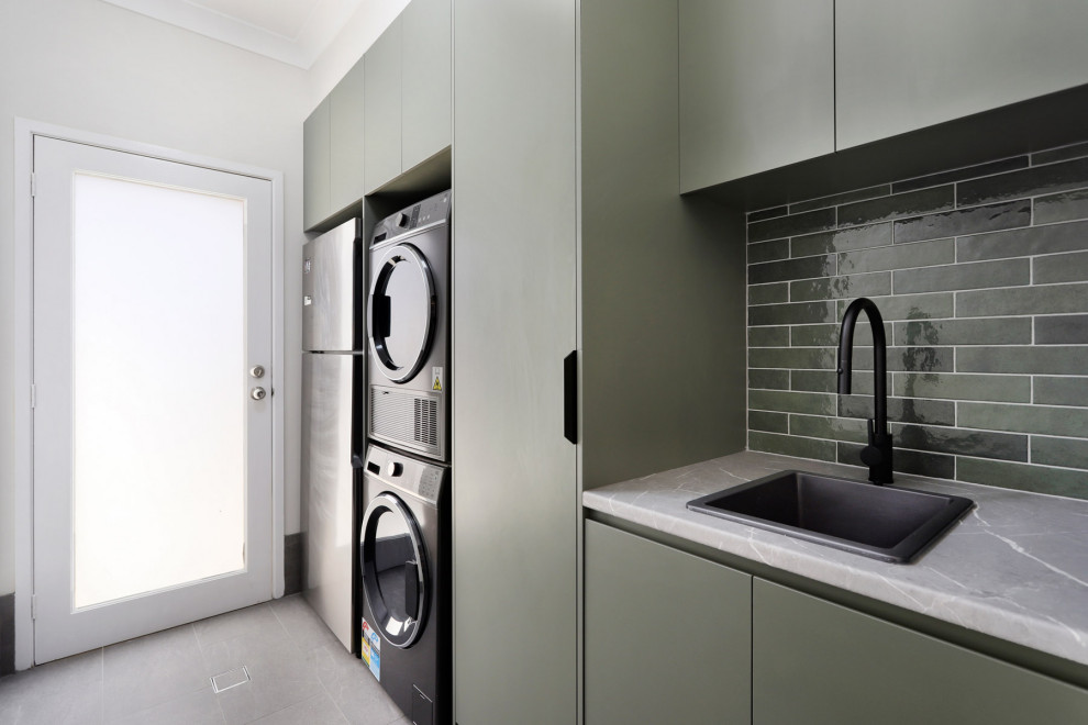 Inspiration for a small contemporary laundry room remodel in Sydney with a single-bowl sink, green cabinets, quartzite countertops, green backsplash, ceramic backsplash and gray countertops