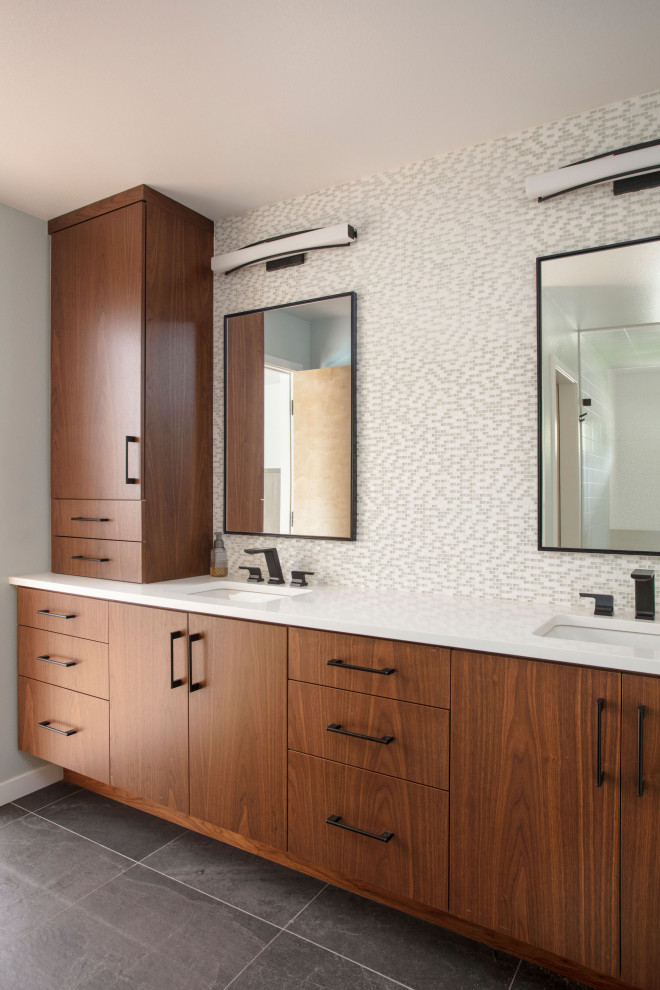 This is an example of a midcentury master bathroom in Denver with flat-panel cabinets, dark wood cabinets, a curbless shower, a bidet, multi-coloured tile, glass tile, blue walls, slate floors, an undermount sink, engineered quartz benchtops, black floor, a hinged shower door, white benchtops, a shower seat, a double vanity and a built-in vanity.