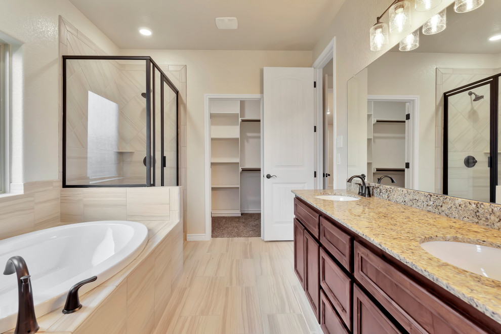 This is an example of a mid-sized modern master bathroom in Austin with dark wood cabinets, a drop-in tub, an alcove shower, a one-piece toilet, beige tile, ceramic tile, white walls, ceramic floors, an undermount sink, granite benchtops, beige floor, a hinged shower door, beige benchtops, an enclosed toilet, a double vanity and a built-in vanity.