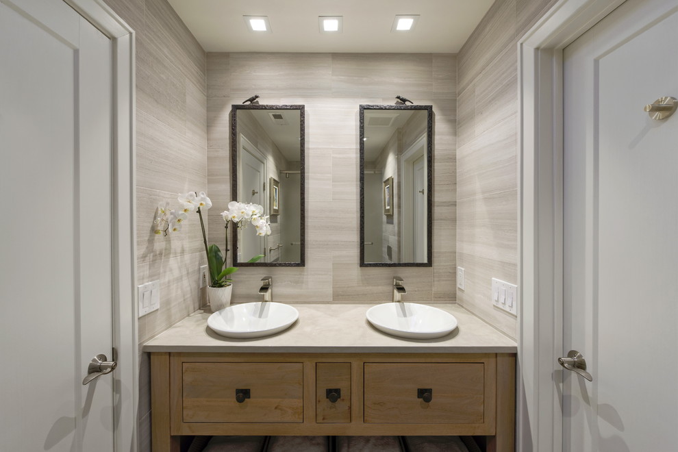 Inspiration for a mid-sized contemporary kids bathroom in DC Metro with furniture-like cabinets, medium wood cabinets, an alcove tub, a shower/bathtub combo, a wall-mount toilet, gray tile, marble, grey walls, slate floors, a vessel sink, limestone benchtops, black floor, a sliding shower screen and grey benchtops.