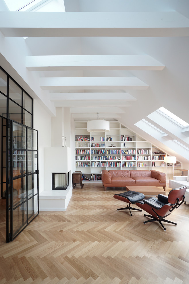 Inspiration for a large contemporary enclosed family room in Berlin with a library, white walls, medium hardwood floors, a two-sided fireplace, a plaster fireplace surround and brown floor.