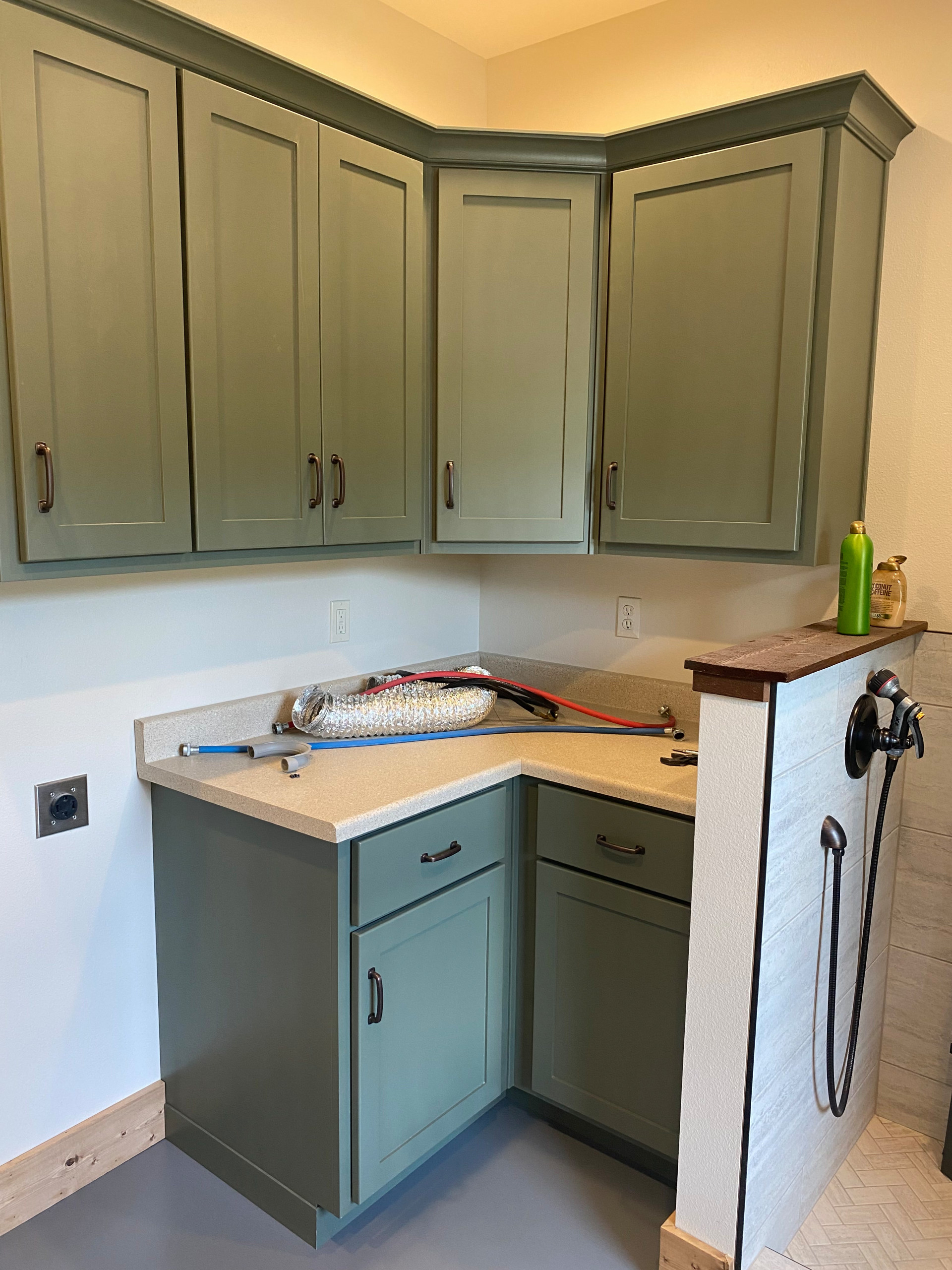 Custom painted laundry room cabinets and tiled dog wash