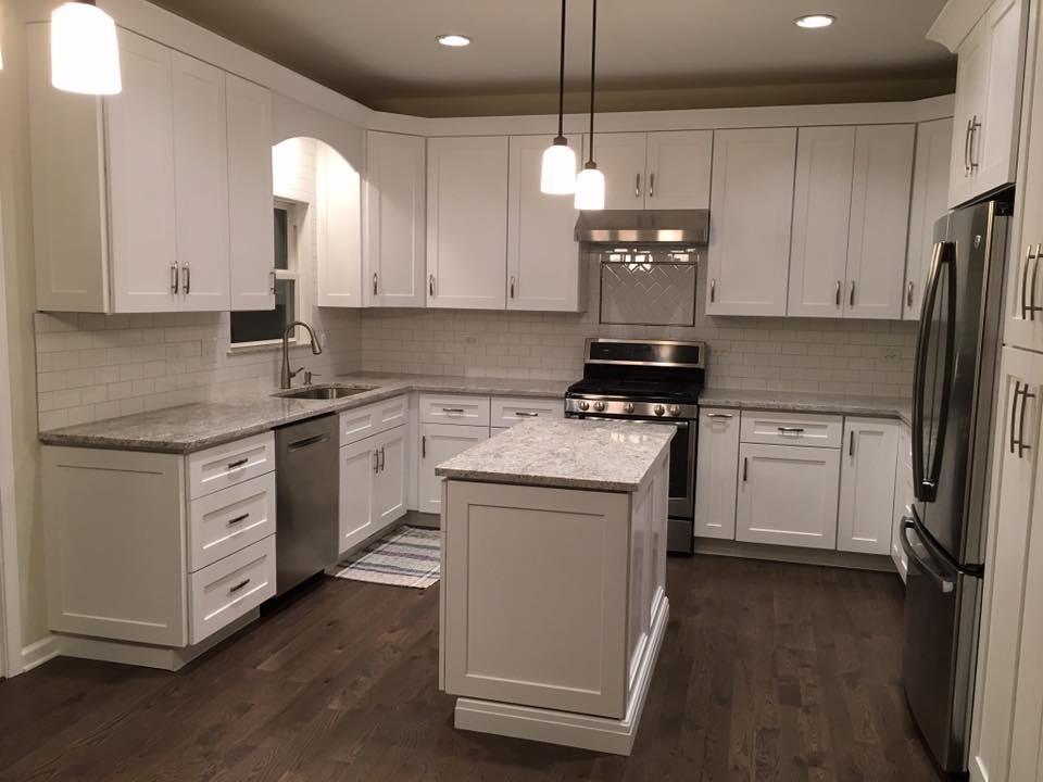 Inspiration for a large transitional u-shaped dark wood floor and brown floor kitchen remodel in Chicago with an undermount sink, shaker cabinets, white cabinets, granite countertops, white backsplash, subway tile backsplash, stainless steel appliances and an island