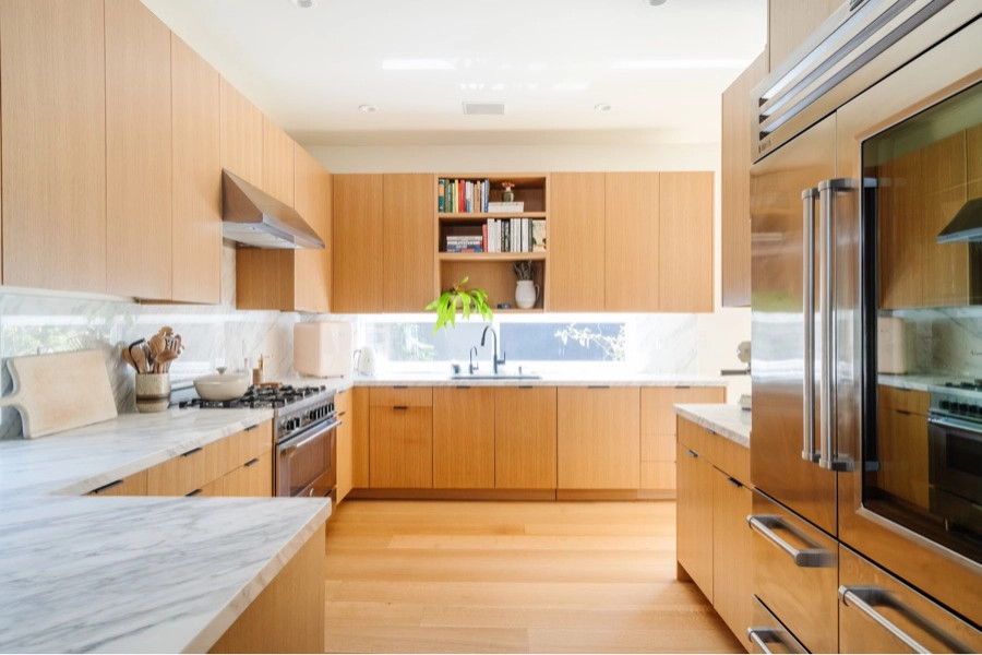 Cette photo montre une cuisine tendance avec un placard à porte plane, un électroménager en acier inoxydable et un sol en bois brun.
