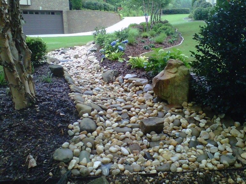Inspiration for a mid-sized modern front yard partial sun driveway for spring in Birmingham with a water feature and gravel.