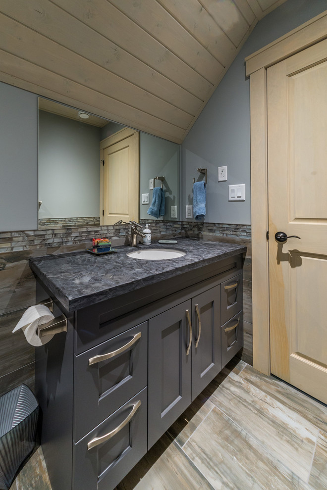 Design ideas for a mid-sized country bathroom in Other with shaker cabinets, grey cabinets, a one-piece toilet, grey walls, medium hardwood floors, an undermount sink, brown floor and grey benchtops.