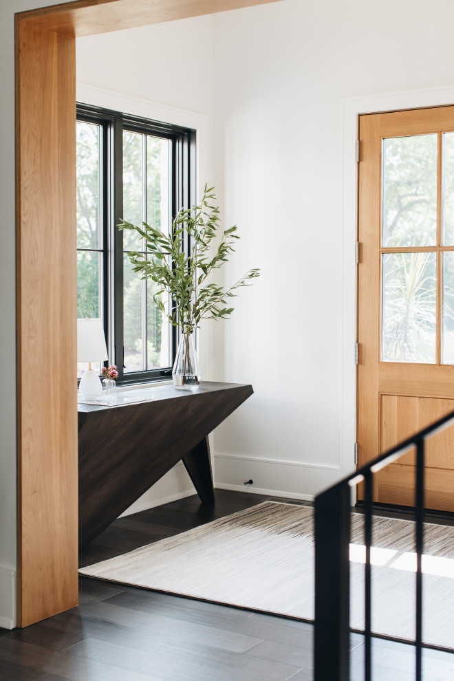 This is an example of a contemporary entryway in Chicago with white walls and brown floor.