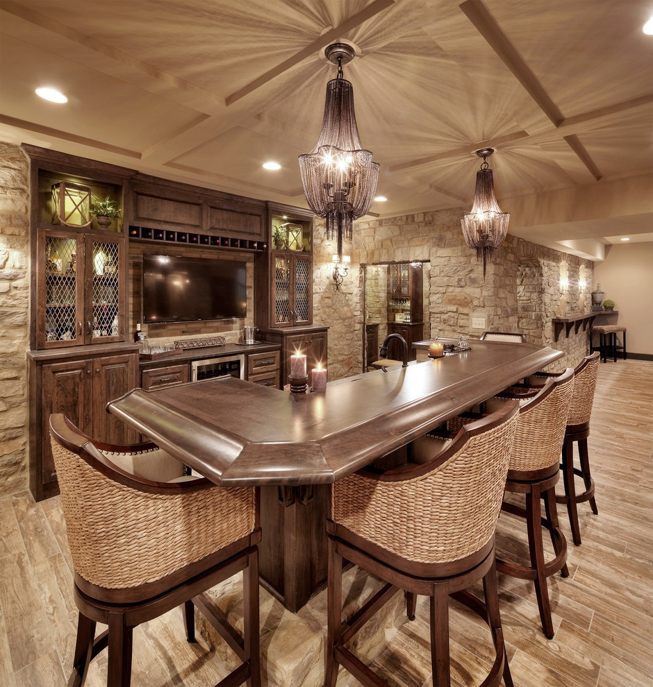 Photo of a mediterranean galley seated home bar in Kansas City with raised-panel cabinets and dark wood cabinets.