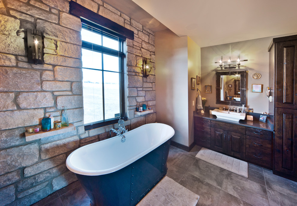 Freestanding bathtub - rustic master gray tile and ceramic tile freestanding bathtub idea with a vessel sink, raised-panel cabinets, dark wood cabinets and quartzite countertops