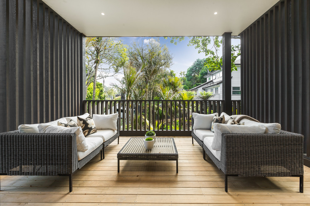 Photo of a mid-sized contemporary side yard deck in Auckland with a roof extension.