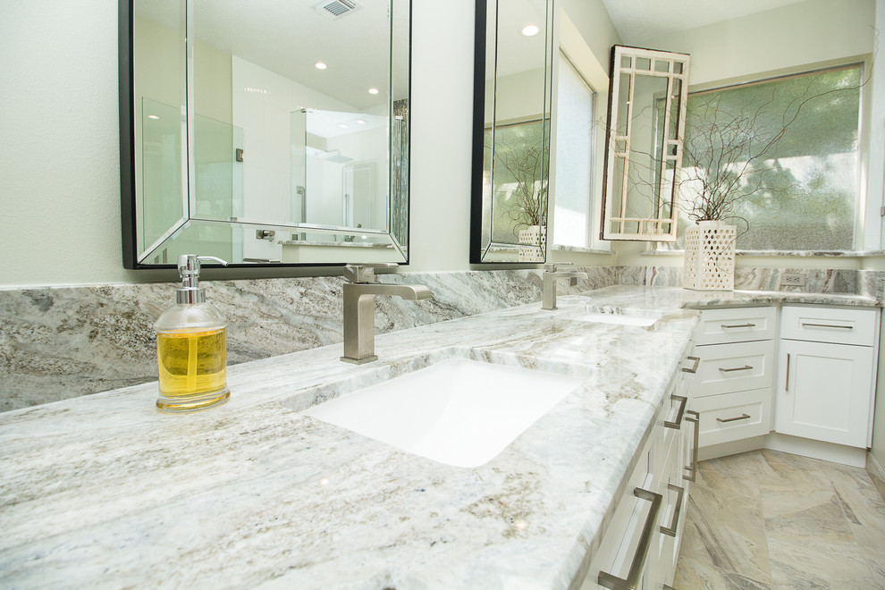 Large contemporary master bathroom in Houston with shaker cabinets, white cabinets, a corner shower, white tile, porcelain tile, grey walls, porcelain floors, an undermount sink, beige floor, a hinged shower door, quartzite benchtops and white benchtops.
