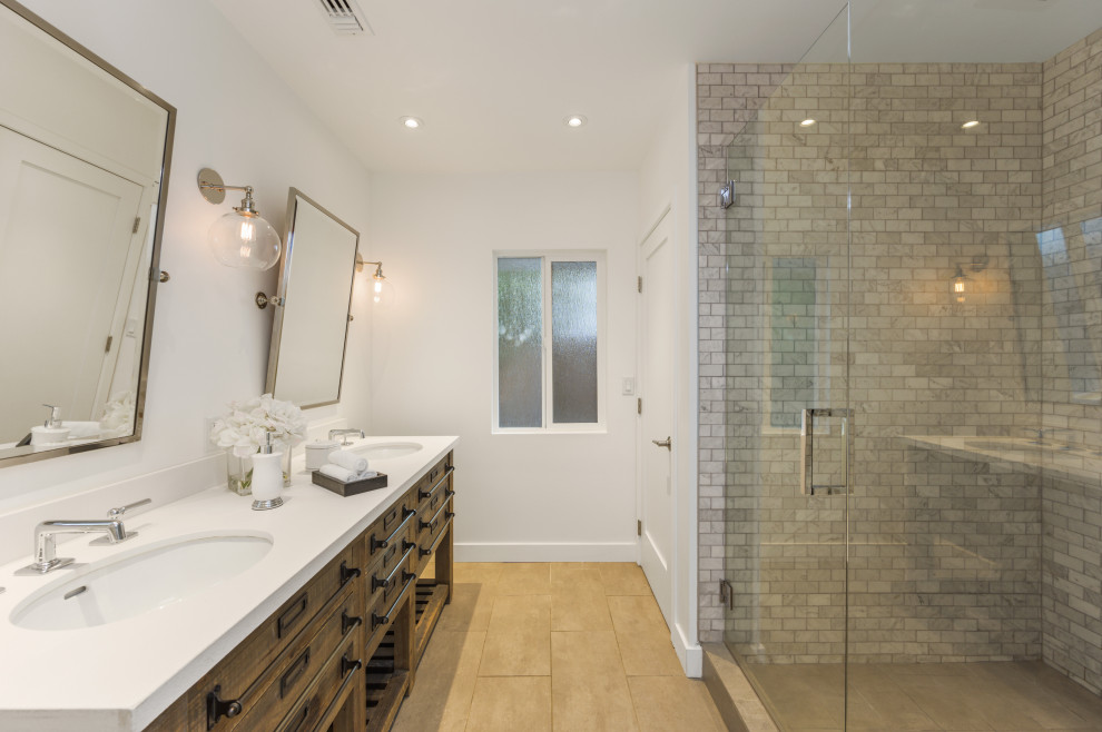 Mid-sized transitional master bathroom in Los Angeles with recessed-panel cabinets, dark wood cabinets, a corner shower, a one-piece toilet, white tile, subway tile, white walls, an undermount sink, engineered quartz benchtops, a hinged shower door, white benchtops, a double vanity and a freestanding vanity.