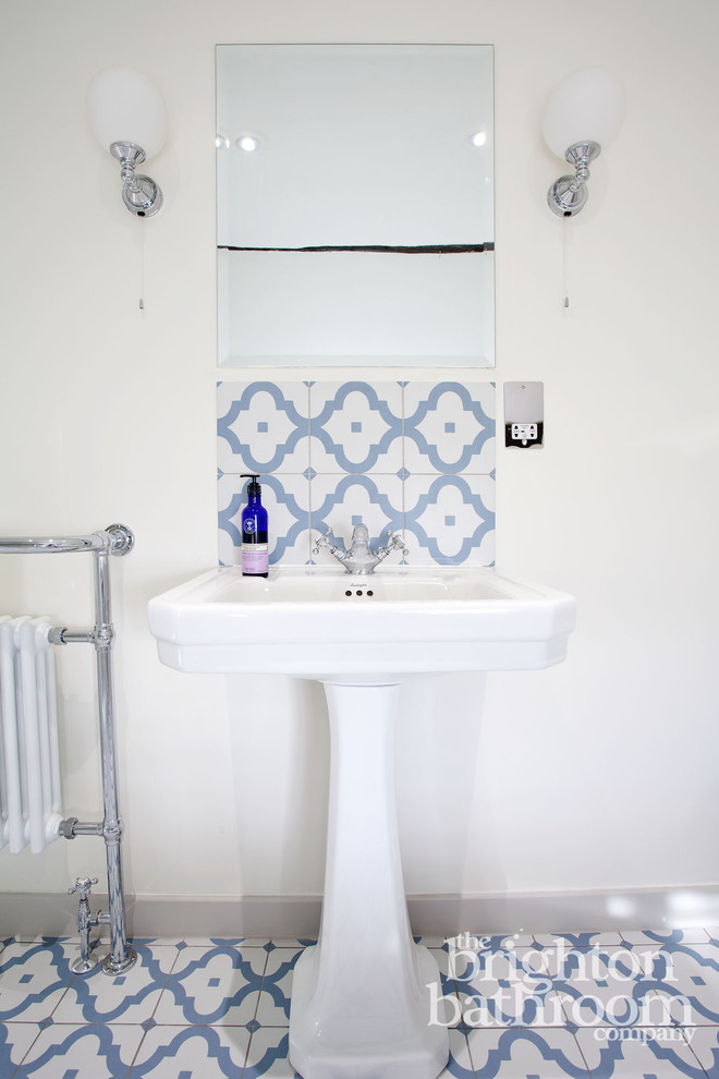 This is an example of a mid-sized traditional kids bathroom in Sussex with shaker cabinets, white cabinets, a freestanding tub, an open shower, a one-piece toilet, multi-coloured tile, ceramic tile, grey walls, ceramic floors and a pedestal sink.