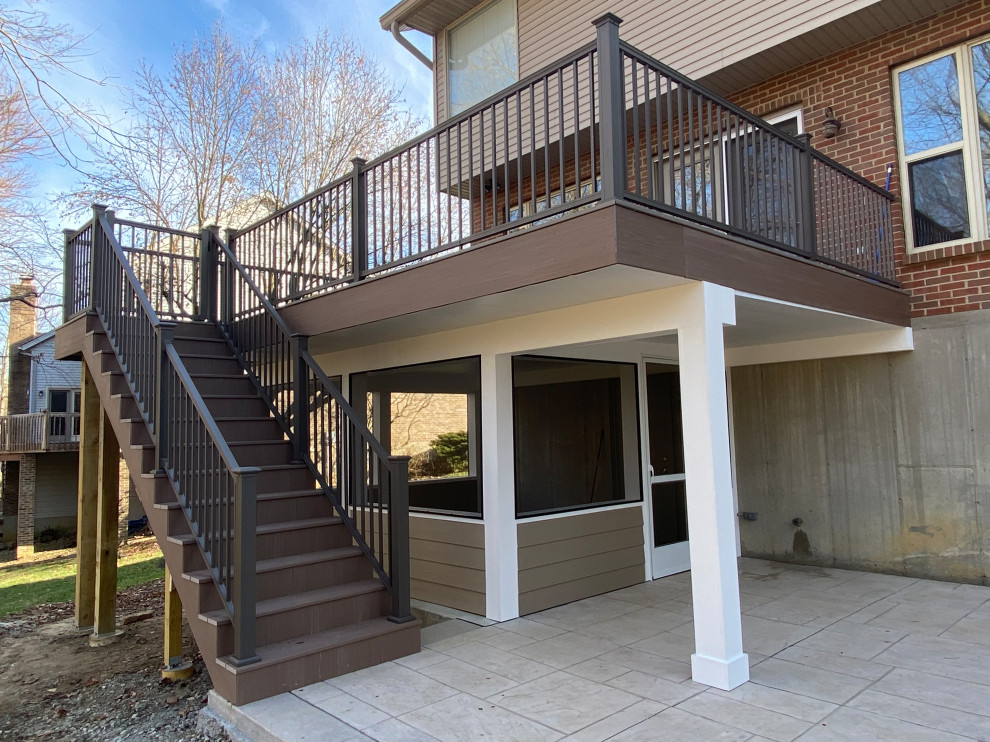 Inspiration for a large transitional backyard and first floor deck in Cincinnati with a roof extension and metal railing.