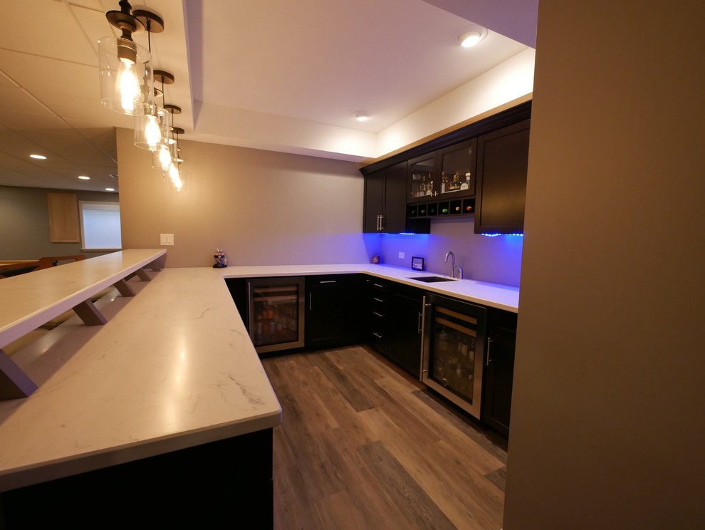 Design ideas for a mid-sized contemporary u-shaped seated home bar in Chicago with an undermount sink, shaker cabinets, black cabinets and white benchtop.
