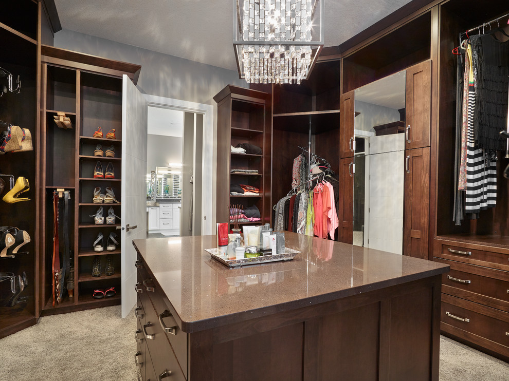 This is an example of a large transitional gender-neutral dressing room in Edmonton with shaker cabinets, carpet, dark wood cabinets and grey floor.