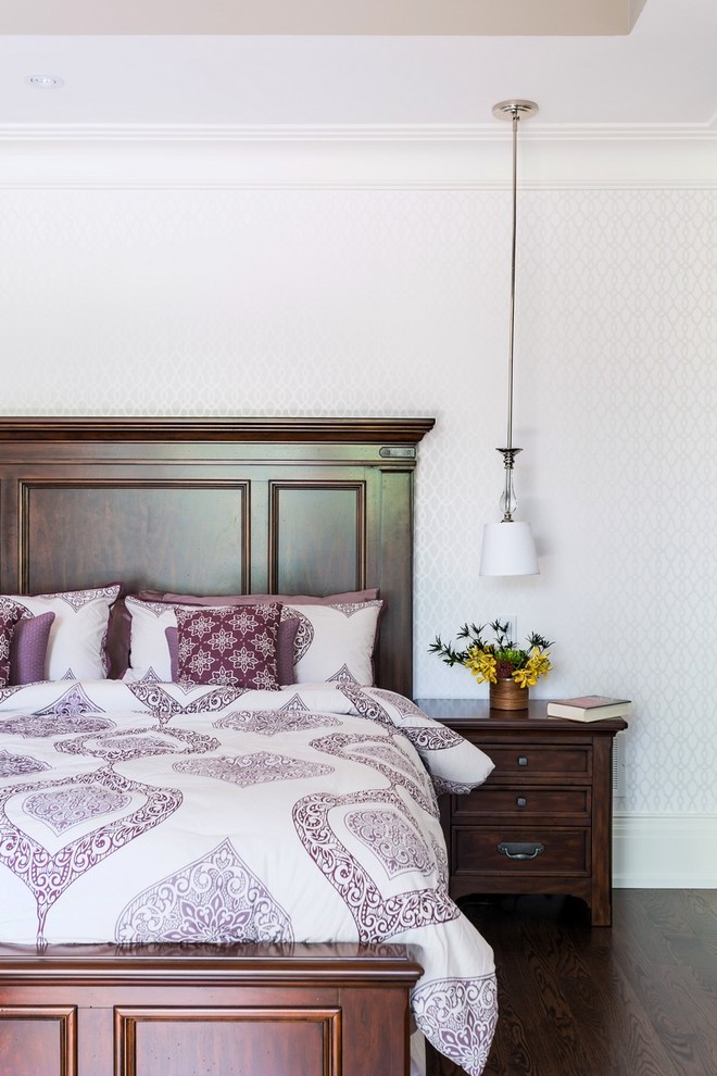 This is an example of a traditional bedroom in Toronto with white walls, dark hardwood floors and no fireplace.