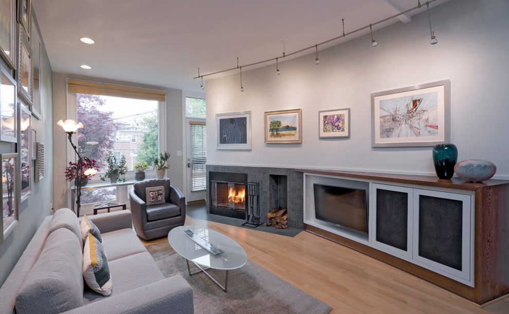 Photo of a medium sized midcentury open plan living room in DC Metro with green walls, light hardwood flooring, a corner fireplace, a stone fireplace surround, a built-in media unit and beige floors.