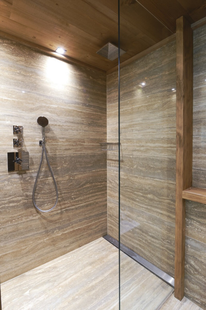 Photo of a traditional bathroom in Lyon with glass-front cabinets, brown tile, travertine and brown walls.