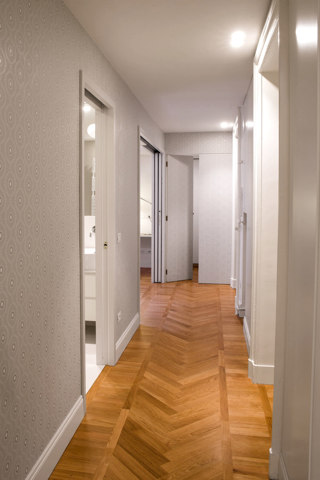 This is an example of a mid-sized contemporary hallway in Milan with multi-coloured walls and medium hardwood floors.