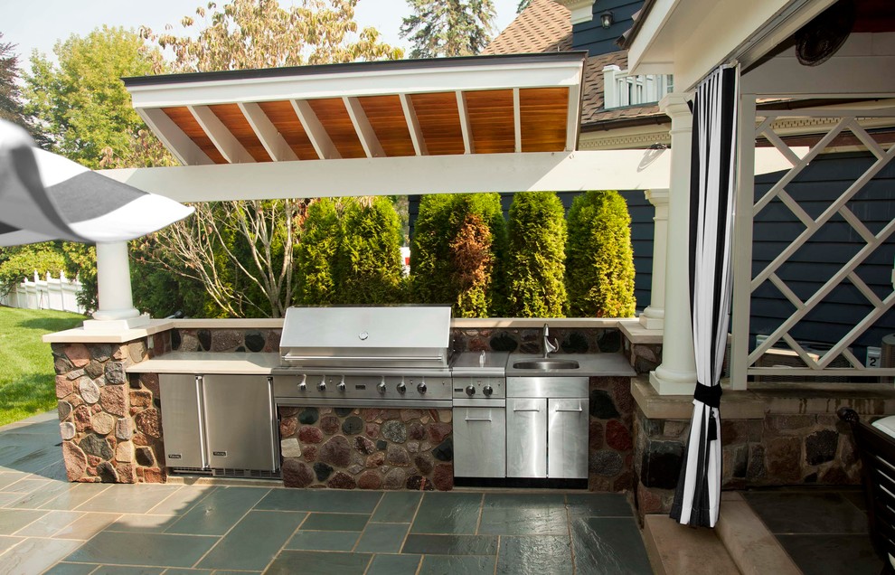 Inspiration for a large traditional backyard patio in Detroit with an outdoor kitchen and a roof extension.