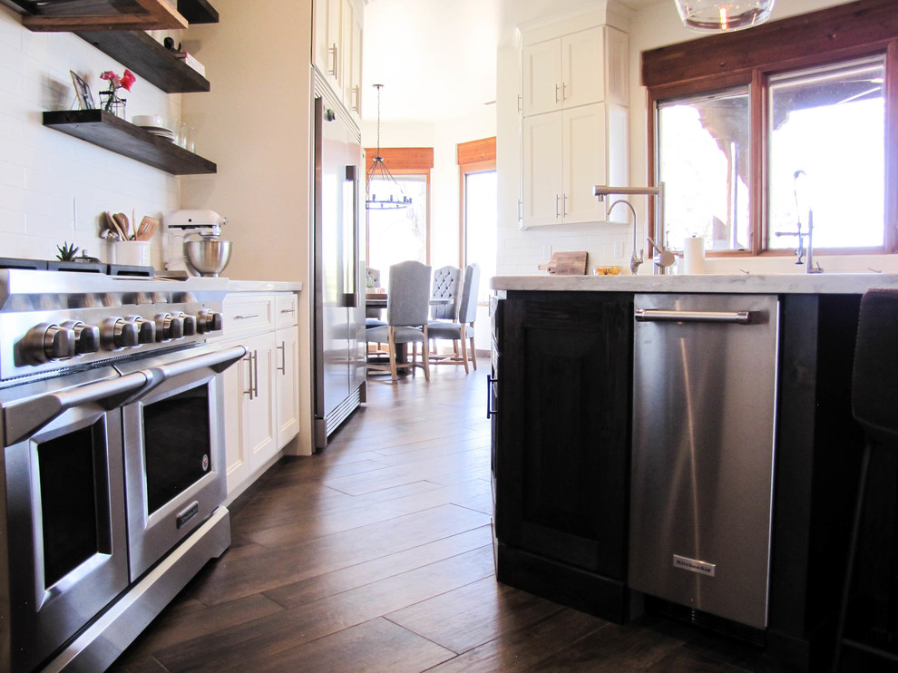 Kitchen - large transitional porcelain tile and brown floor kitchen idea in Phoenix with white backsplash, subway tile backsplash, stainless steel appliances and an island