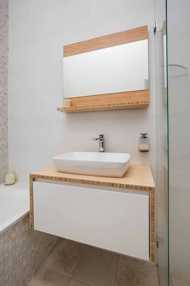 Mid-sized beach style master bathroom in Sydney with white cabinets, a drop-in tub, a corner shower, a wall-mount toilet, beige tile, mosaic tile, white walls, ceramic floors and wood benchtops.