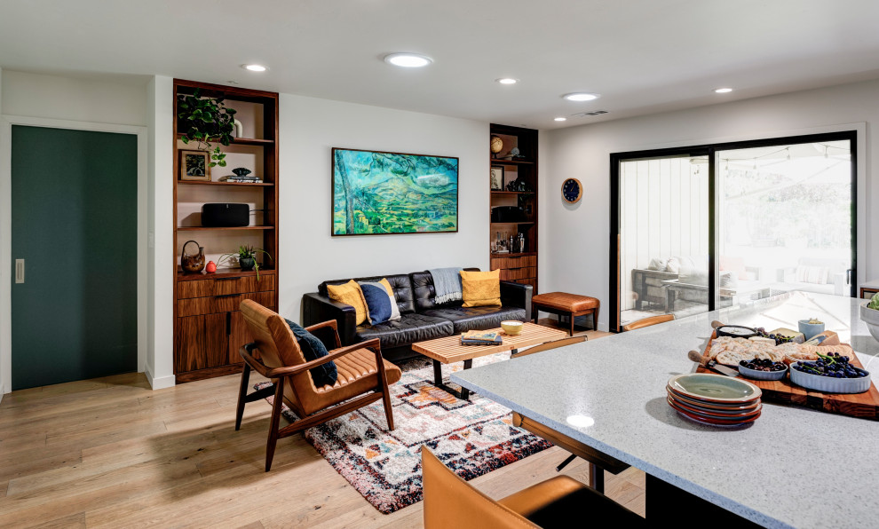 Esempio di un soggiorno minimalista di medie dimensioni e aperto con parquet chiaro, TV a parete e pavimento marrone
