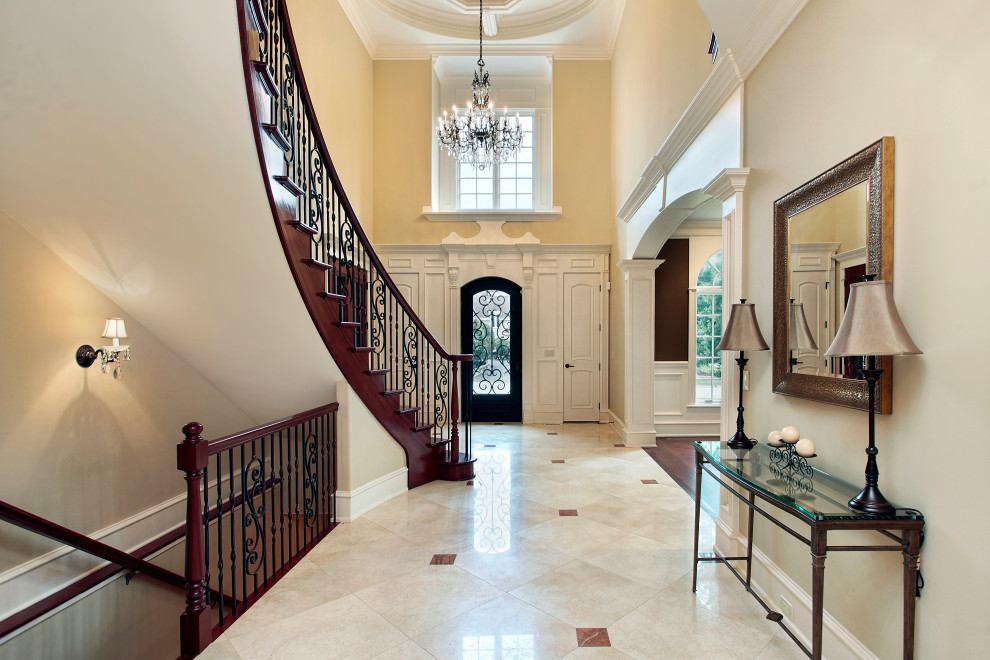 Foto di un grande ingresso con pareti beige, pavimento in marmo, una porta singola, una porta in legno scuro, pavimento beige, soffitto ribassato e pannellatura