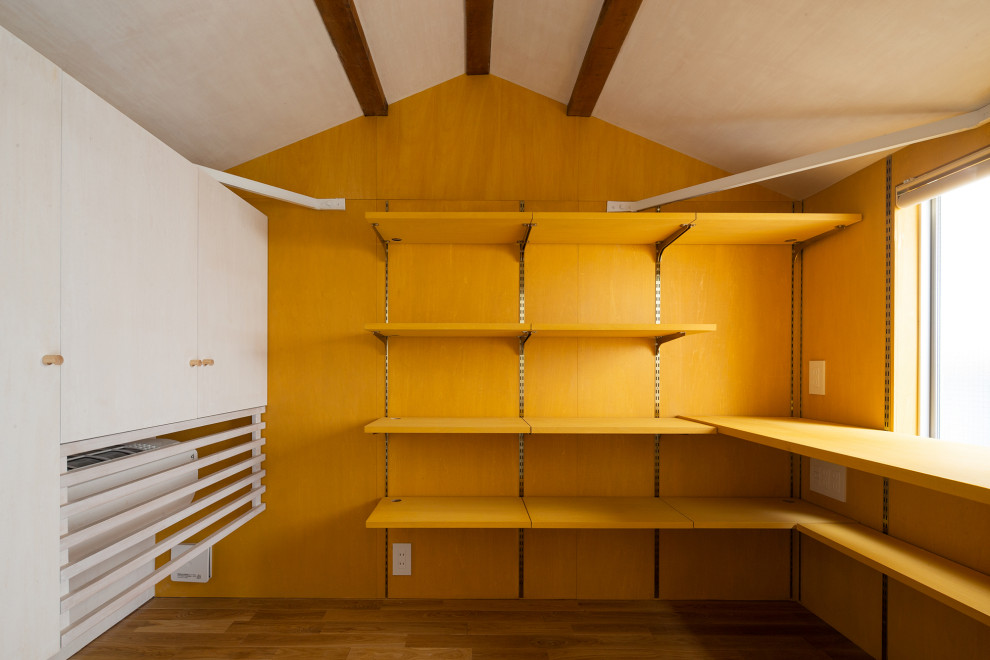 Idées déco pour une petite chambre mansardée ou avec mezzanine avec un mur jaune, un sol en bois brun, un sol marron, un plafond en bois et du lambris de bois.