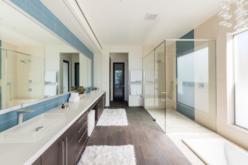 Design ideas for a contemporary master bathroom in San Luis Obispo with flat-panel cabinets, brown cabinets, a drop-in tub, a curbless shower, blue tile, white walls, a vessel sink, brown floor, a hinged shower door and white benchtops.