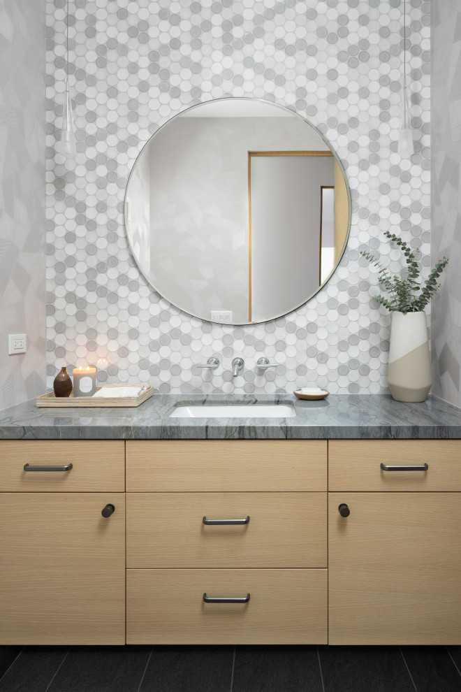 Photo of a large contemporary cloakroom in Orange County with flat-panel cabinets, light wood cabinets, a two-piece toilet, multi-coloured tiles, ceramic tiles, grey walls, light hardwood flooring, a submerged sink, quartz worktops, blue worktops, a floating vanity unit and wallpapered walls.