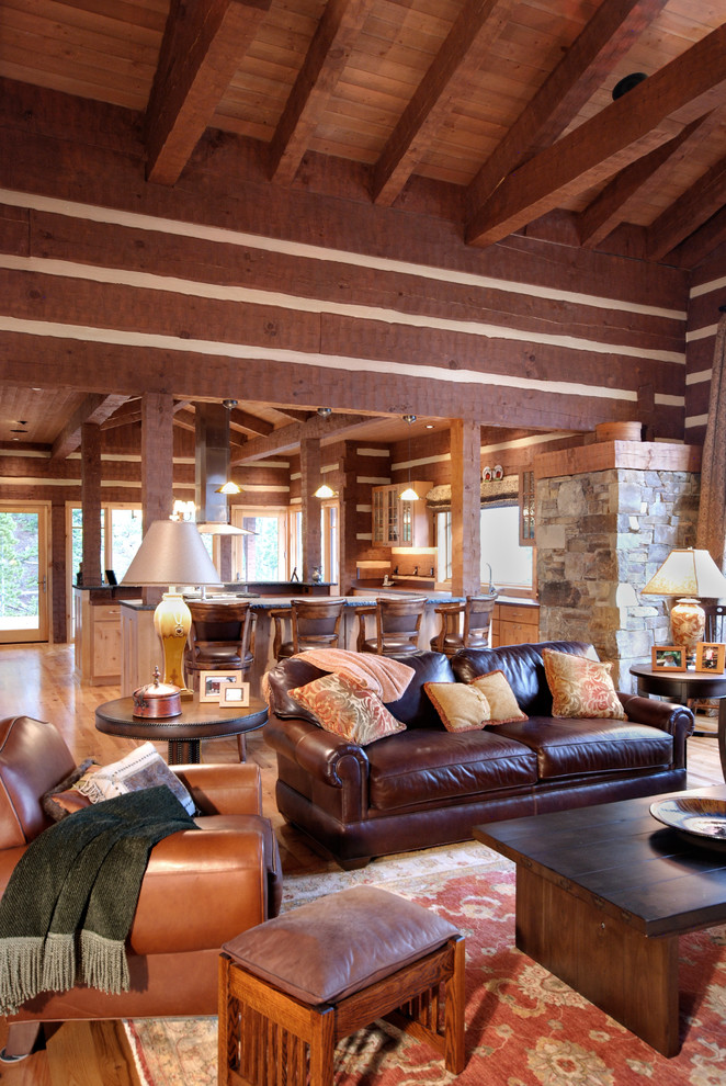 Inspiration for a mid-sized country open concept living room in Other with brown walls, light hardwood floors, a standard fireplace and a stone fireplace surround.