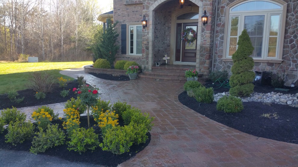 Inspiration for a large traditional front yard patio in New York with brick pavers and no cover.