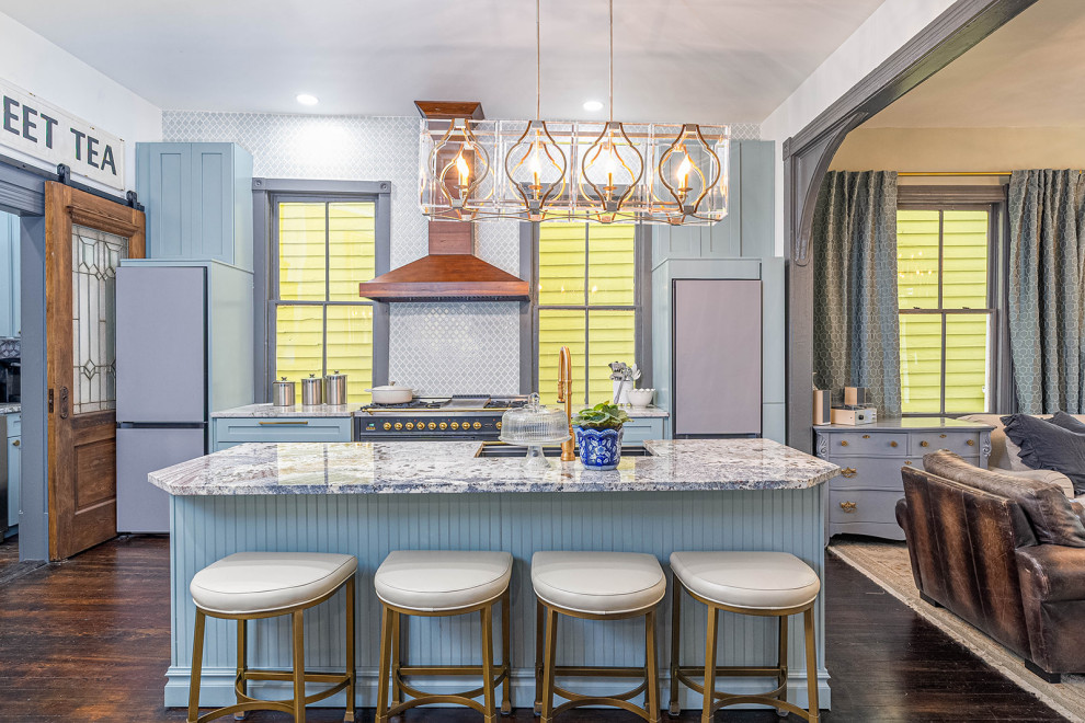 Example of a large transitional galley dark wood floor and black floor eat-in kitchen design with a farmhouse sink, shaker cabinets, blue cabinets, granite countertops, blue backsplash, ceramic backsplash, black appliances, an island and white countertops