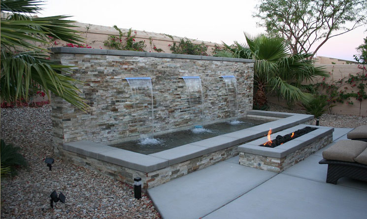 Design ideas for a mid-sized tropical backyard patio in Los Angeles with a water feature, no cover and concrete slab.