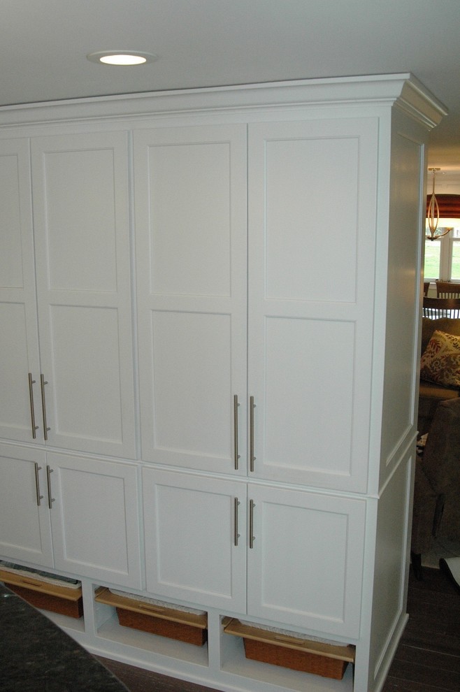 Enclosed kitchen - mid-sized transitional l-shaped medium tone wood floor and brown floor enclosed kitchen idea in Boston with an undermount sink, recessed-panel cabinets, white cabinets, granite countertops, multicolored backsplash, glass tile backsplash, stainless steel appliances and an island