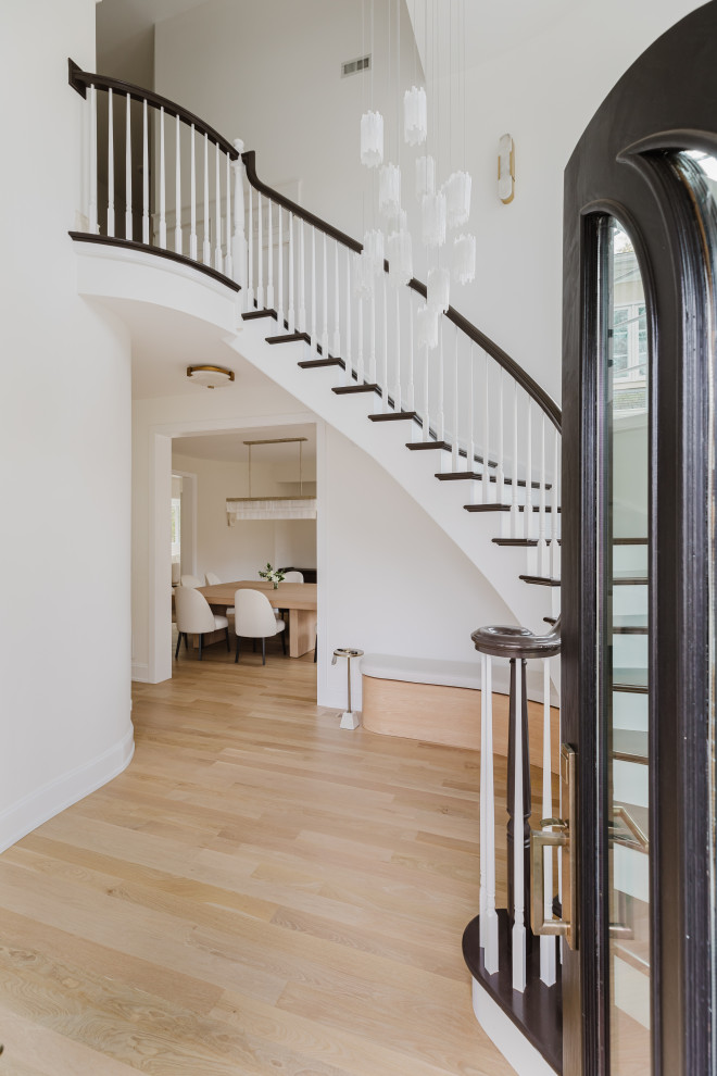 Elegant Home Interior Entrance With Curved Staircase and Black Double Doors