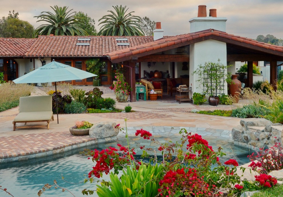 Photo of an expansive mediterranean backyard garden in San Diego with natural stone pavers.