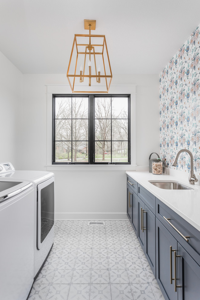 Country single-wall dedicated laundry room in Indianapolis with an undermount sink, shaker cabinets, grey cabinets, multi-coloured walls, a side-by-side washer and dryer, multi-coloured floor and white benchtop.