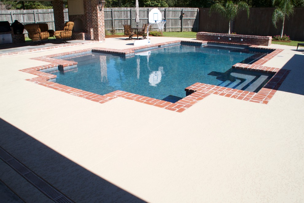 Mid-sized traditional backyard custom-shaped lap pool in New Orleans with concrete slab.