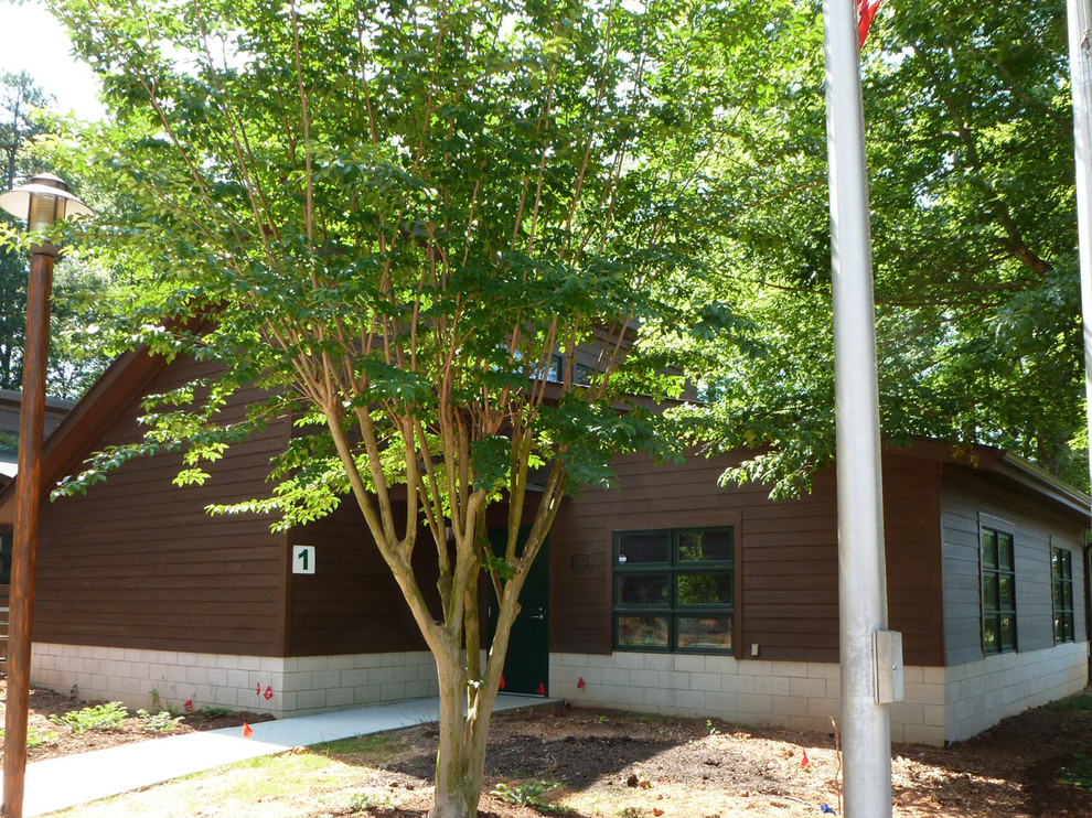 This is an example of a large country one-storey concrete brown exterior in Charlotte.