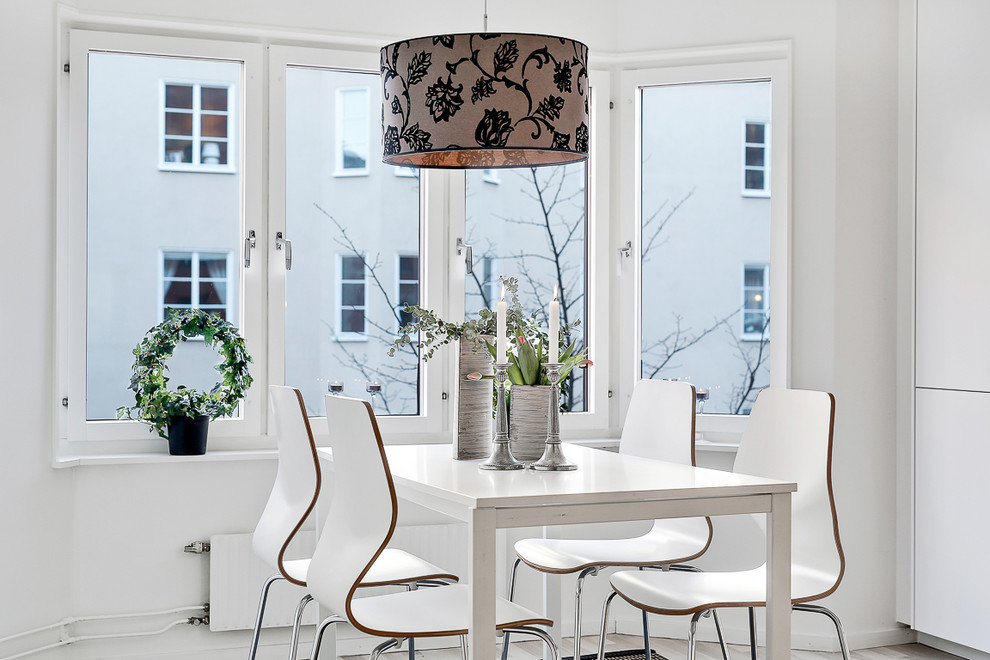 This is an example of a mid-sized scandinavian dining room in Stockholm with white walls, no fireplace and light hardwood floors.
